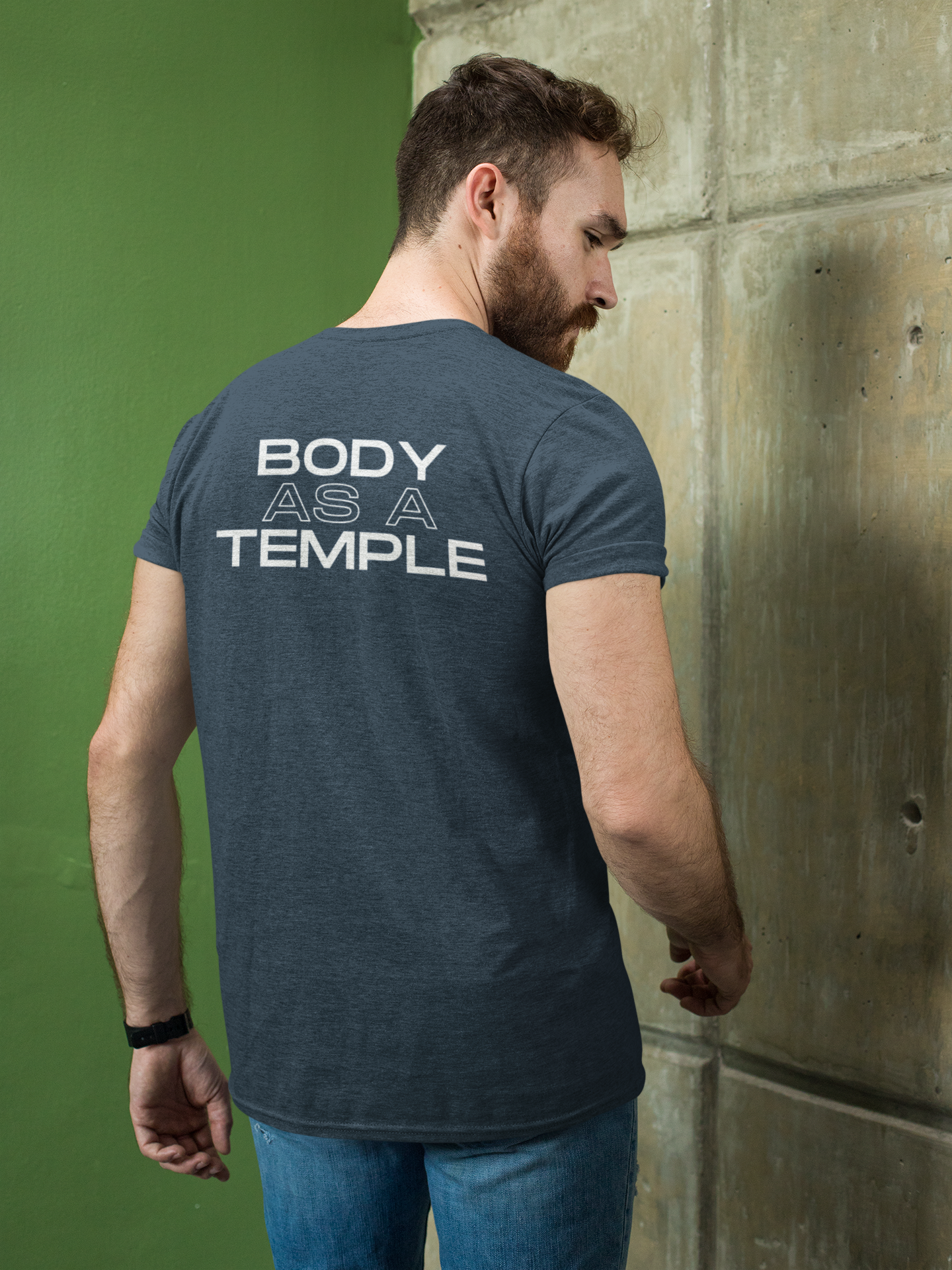 A Christian man confidently wearing a Indigo shirt with the message 'Body As A Temple' on the back. His hands are in his pockets, conveying a sense of determination for Christ-centered fitness.